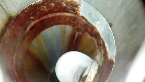 Camerabeeld van de binnenkant van een aluminium rookgasafvoer met roestbruine aantasting